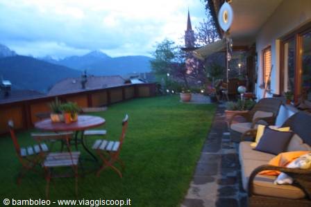 Table with flowers on lawn, church steeple and mountains at dusk