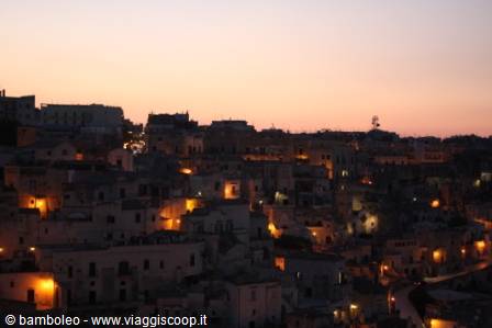 The Sassi of Matera lit at dusk, golden lights among the tufa houses