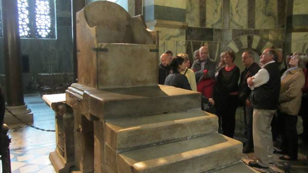 Tourists gathered around Charlemagne's throne in Aachen Cathedral