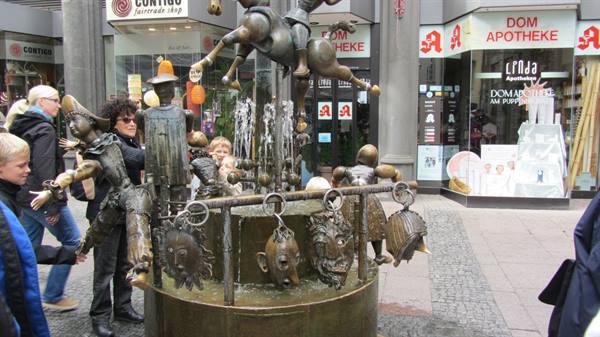 Bronze fountain with sculpted figures in Cologne, near the Dom Apotheke