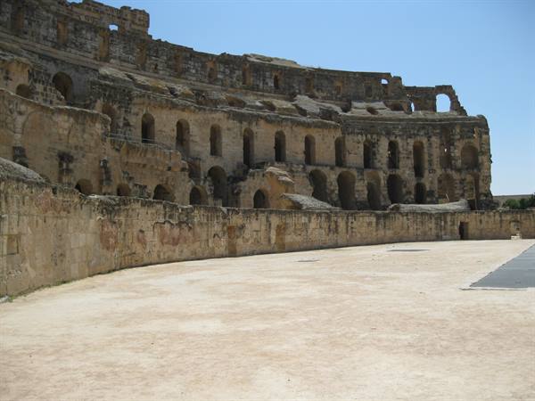 El Jem amphitheater: stone tiers and sandy arena under bright sun