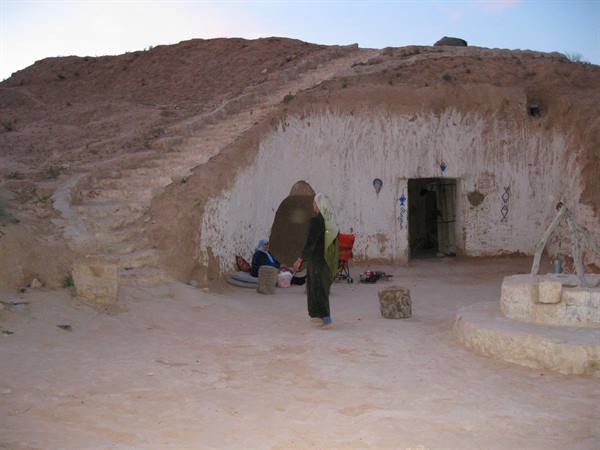 Woman in traditional clothes outside a troglodyte cave house, Matmata