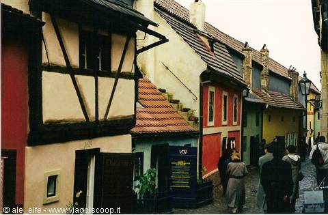 Tourists walk along Golden Lane, colorful small houses in Prague
