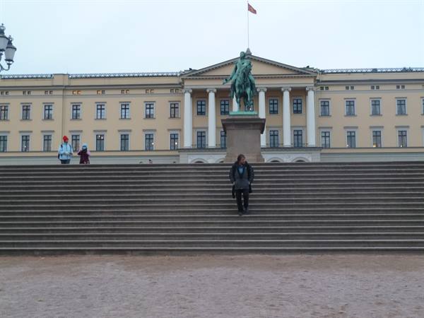 Tourist on the grand stairs of Oslo Royal Palace with equestrian statue