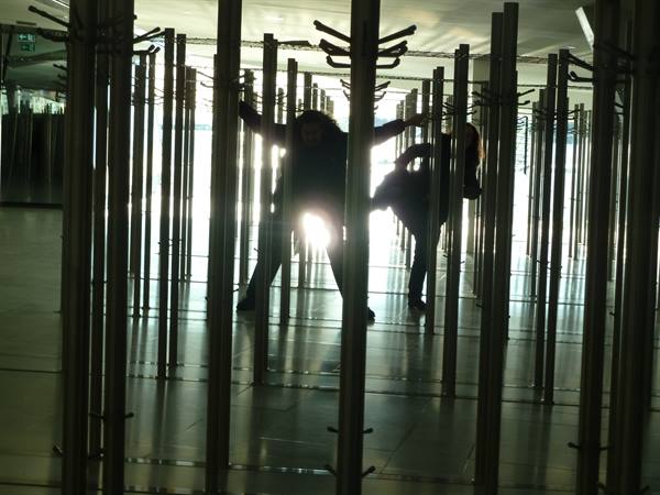 Visitor silhouettes among metal pole installations in the bright Oslo Opera House foyer