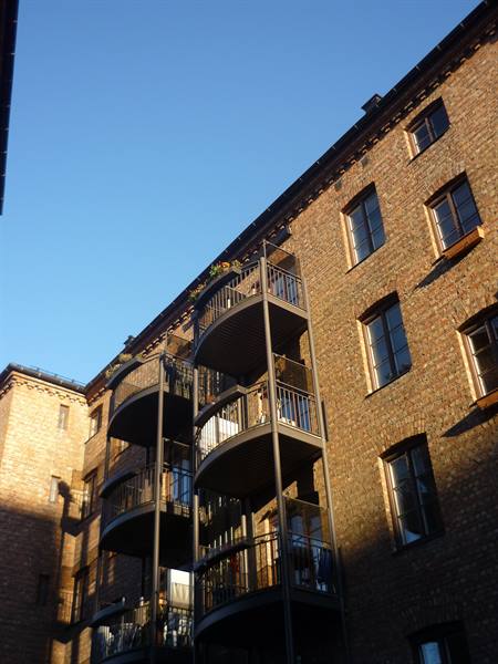 Brick facade with metal balconies in Oslo, golden morning light