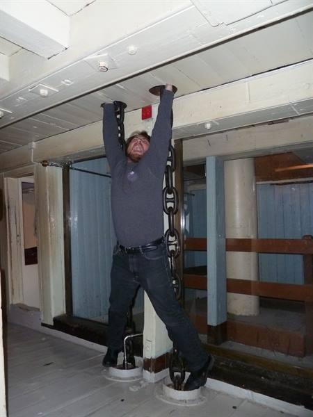 Tourist hanging from an iron chain aboard a museum ship in Oslo
