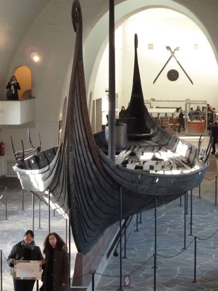 Wooden Viking ship at the Viking Ship Museum in Oslo, visitors below