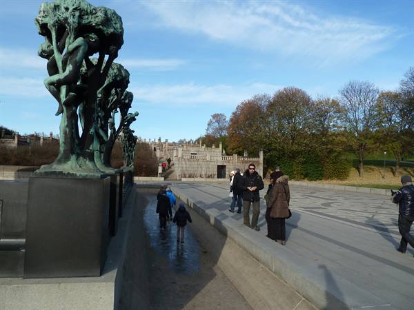 Bronze statues at Vigeland Park in Oslo, visitors walking along the avenue