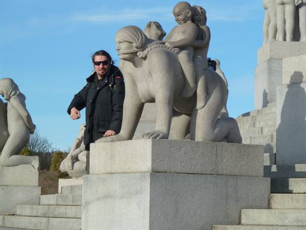Tourist next to a granite sculpture in Vigeland Park, Oslo