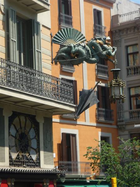 Drago e ombrello appesi alla facciata della Rambla, Barcellona