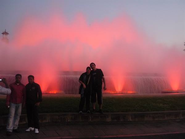 Tourists pose in front of Montjuïc fountain lit in pink, Barcelona
