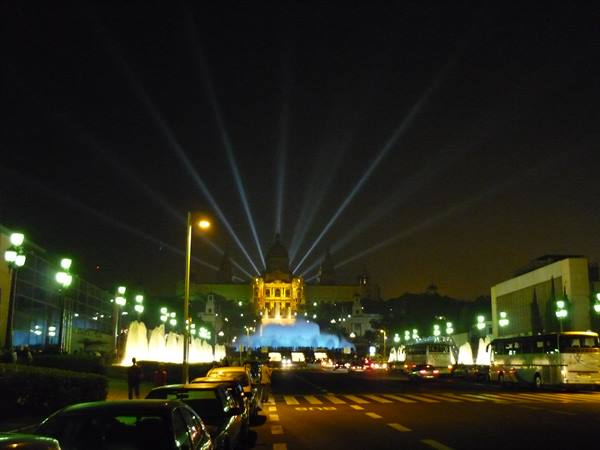 Magic Fountain of Montjuïc lit at night, light beams over the palace