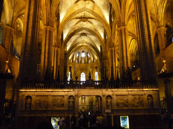 Gothic nave of Barcelona's Cathedral of Santa Eulalia, lit in golden light