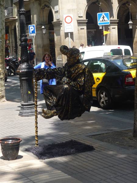 Golden mime levitating on a cane, living statue on La Rambla
