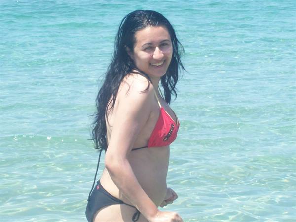 Smiling woman in red and black bikini in clear green water