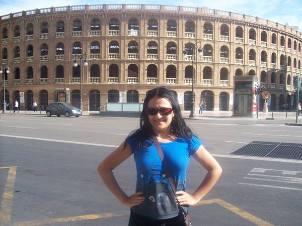 Girl with sunglasses in front of Valencia's Plaza de Toros bullring, sunny morning