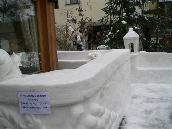 Snow sculptures outside a bar with a please do not touch sign