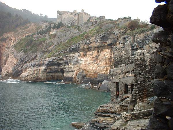 Ancient stone houses by the sea in Portovenere, Doria castle on the cliff above