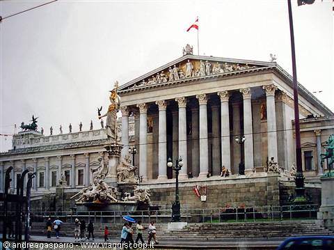 Tourists in front of Vienna's Parliament with marble columns and Athena fountain