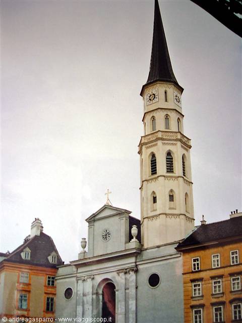 St. Michael's Church in Vienna with white tower and dark spire among buildings