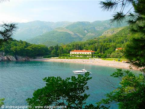 Villa with red roof on Miločer beach, boat anchored among pine trees