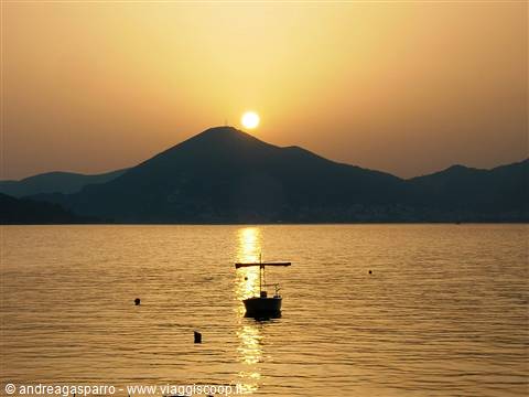 Anchored boat in front of the mountain glowing under the low sun