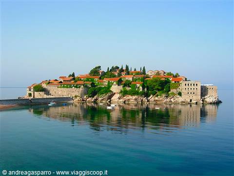 Sveti Stefan: stone village with red roofs reflected in calm sea