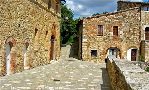 Stone-paved lane between medieval stone houses in Monteriggioni