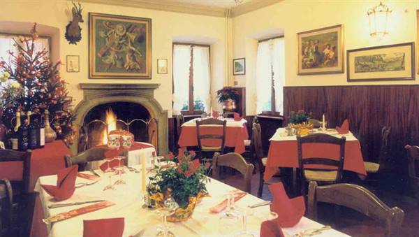 Restaurant dining room with set tables, lit fireplace and Christmas tree