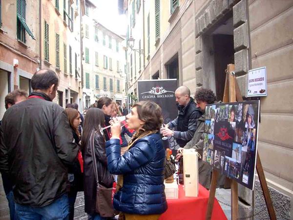 Wine tasting stall in a narrow alley, woman sipping from a glass