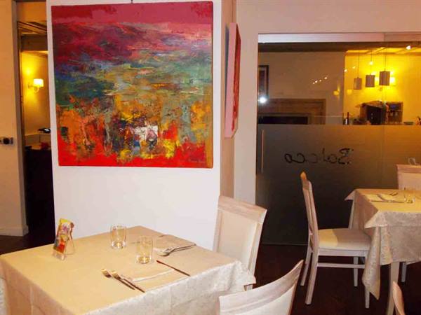 Baloca restaurant dining room with set tables and red abstract painting