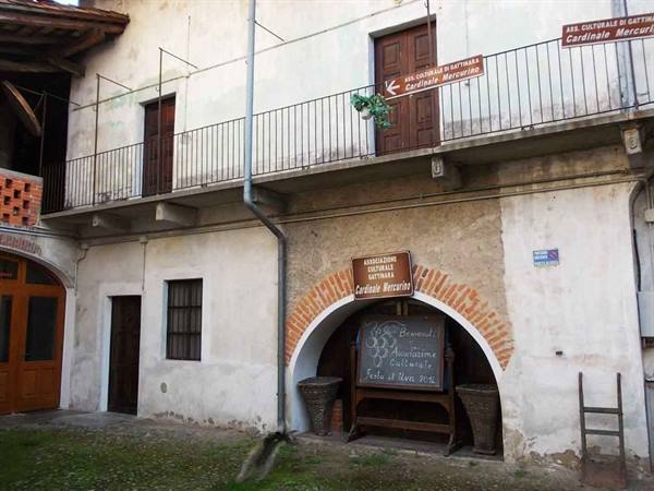 Wooden-sign winery in Gattinara under a brick archway