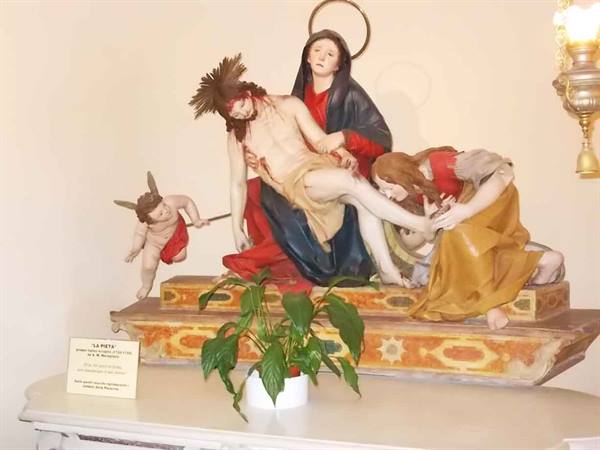 Pietà statue: Mary holds Christ's body, angel and mourning woman beside