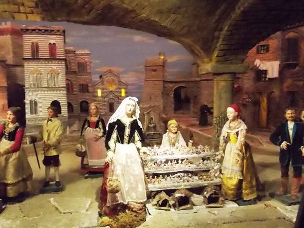Neapolitan nativity scene: costumed figures gathered around a market stall