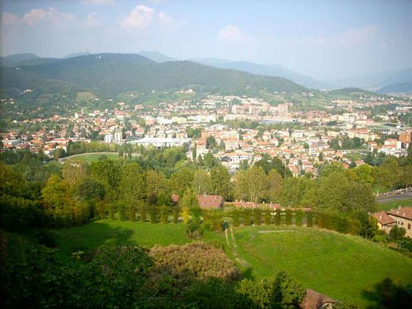 Town nestled among green hills, rooftops and houses seen from above