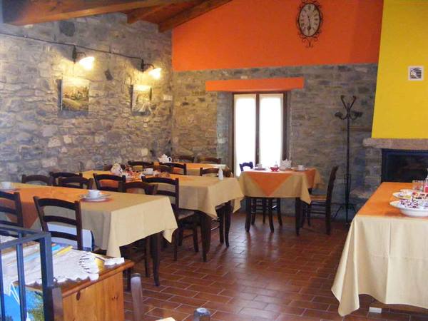 Stone breakfast room with set tables and yellow tablecloths