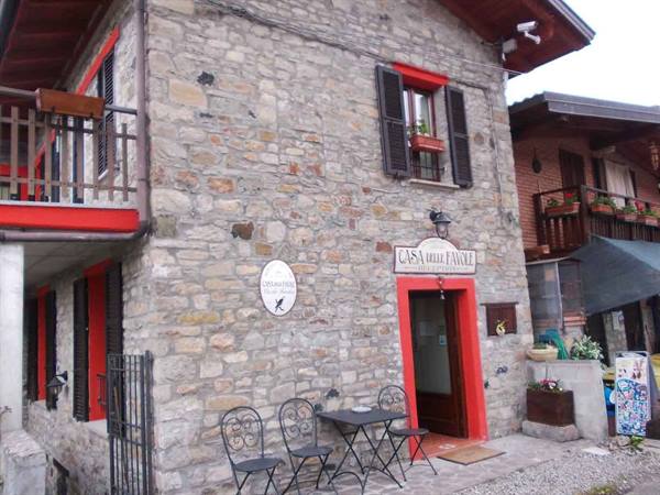 Casa del Parco, stone building with sign and wrought-iron tables outside the entrance
