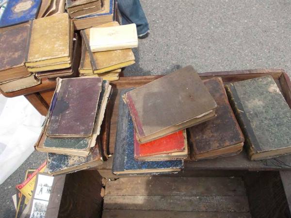 Worn old books for sale on a wooden crate at a flea market