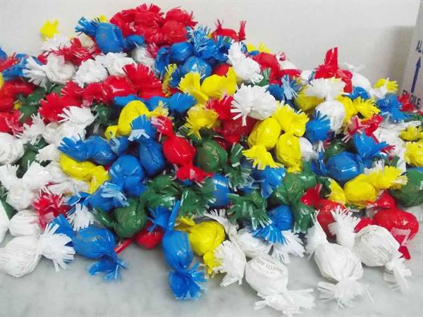Pile of colorful wrapped candies on white marble