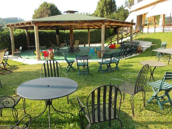 Hotel garden with wrought iron tables and wooden pavilion on the lawn