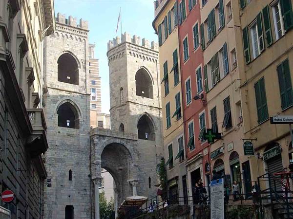 Porta Soprana in Genoa, medieval stone towers among colorful buildings