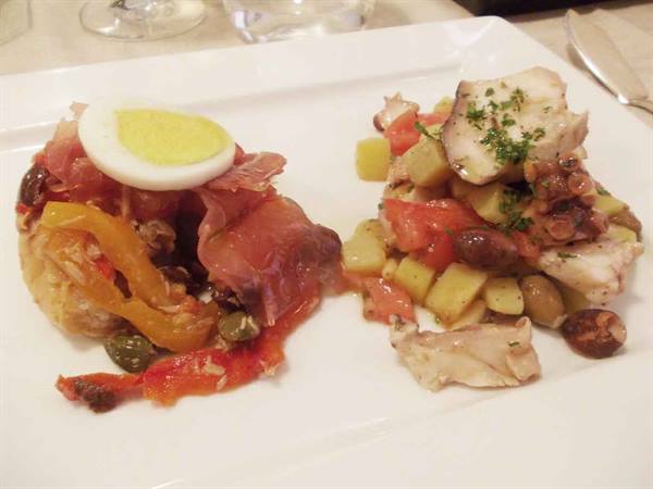 White plate with ham, boiled egg and octopus potato salad