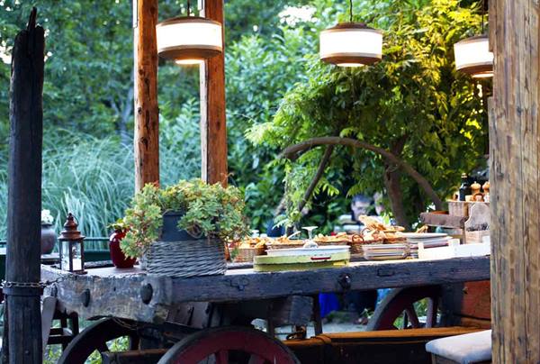 Old wooden wagon used as buffet, hanging lanterns and greenery all around