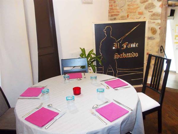 Table set with white tablecloth and pink napkins at Il Fante Sabaudo restaurant