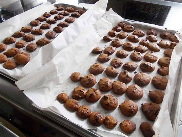 Freshly baked cookies on parchment-lined baking trays, home kitchen