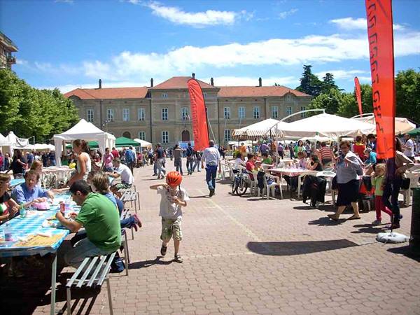 Child in orange helmet runs among market stalls in a crowded square