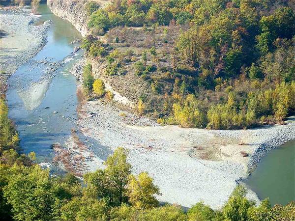 River winding through gravel banks and autumn woods, sunlight on water