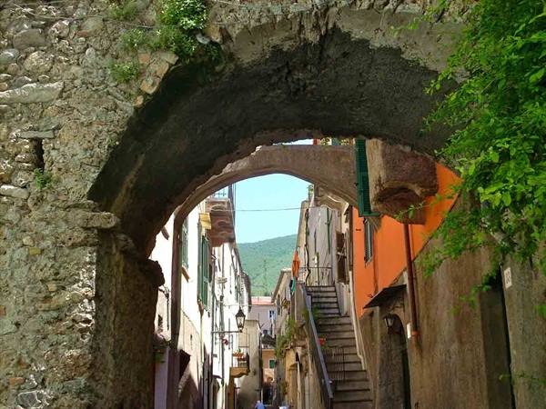 Medieval stone arch over alley with staircase and colorful houses
