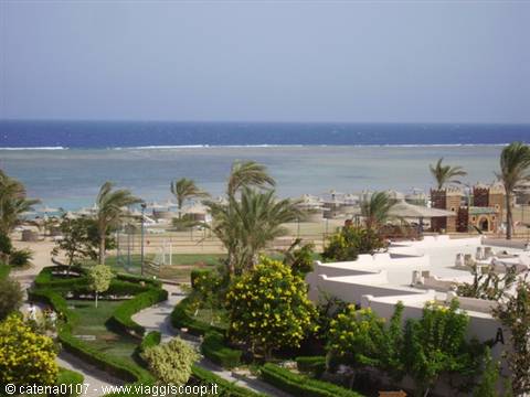 Resort pools and palm trees facing the sandy beach and turquoise sea